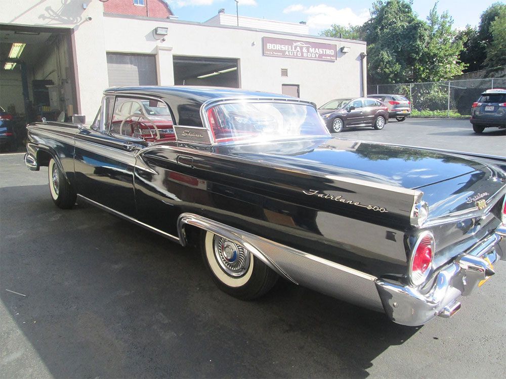 Classic black vintage car parked outdoors in front of a building