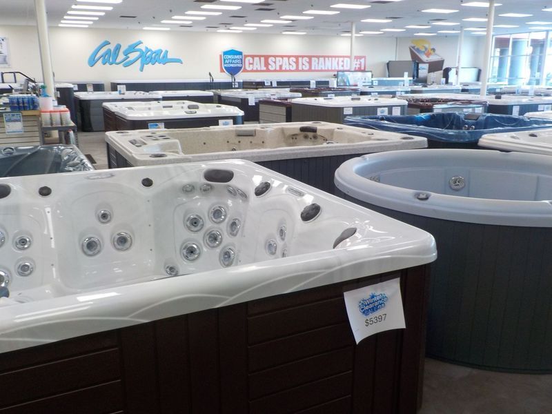 A showroom display of multiple hot tubs and spas with a large 