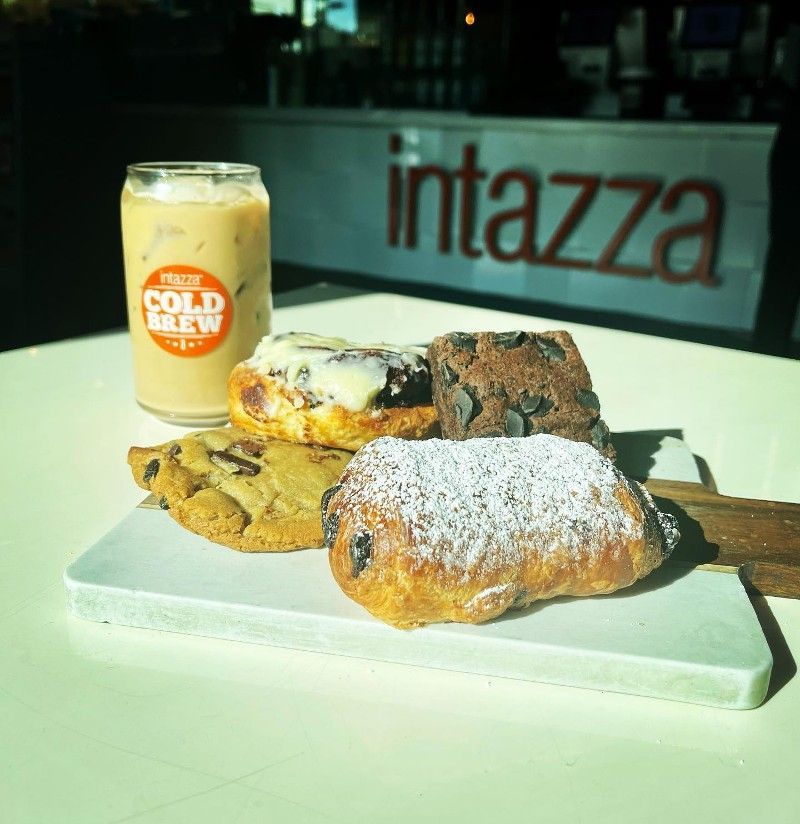 A can of cold brew sits on a table next to some pastries