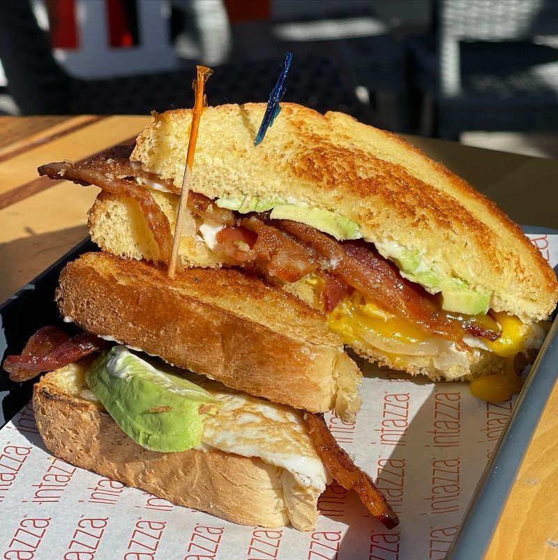 A close up of a sandwich on a tray that says pizza