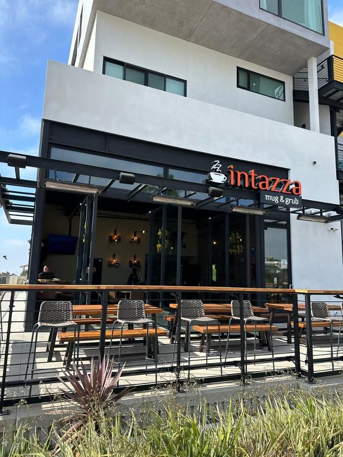 A restaurant with tables and chairs outside of it.