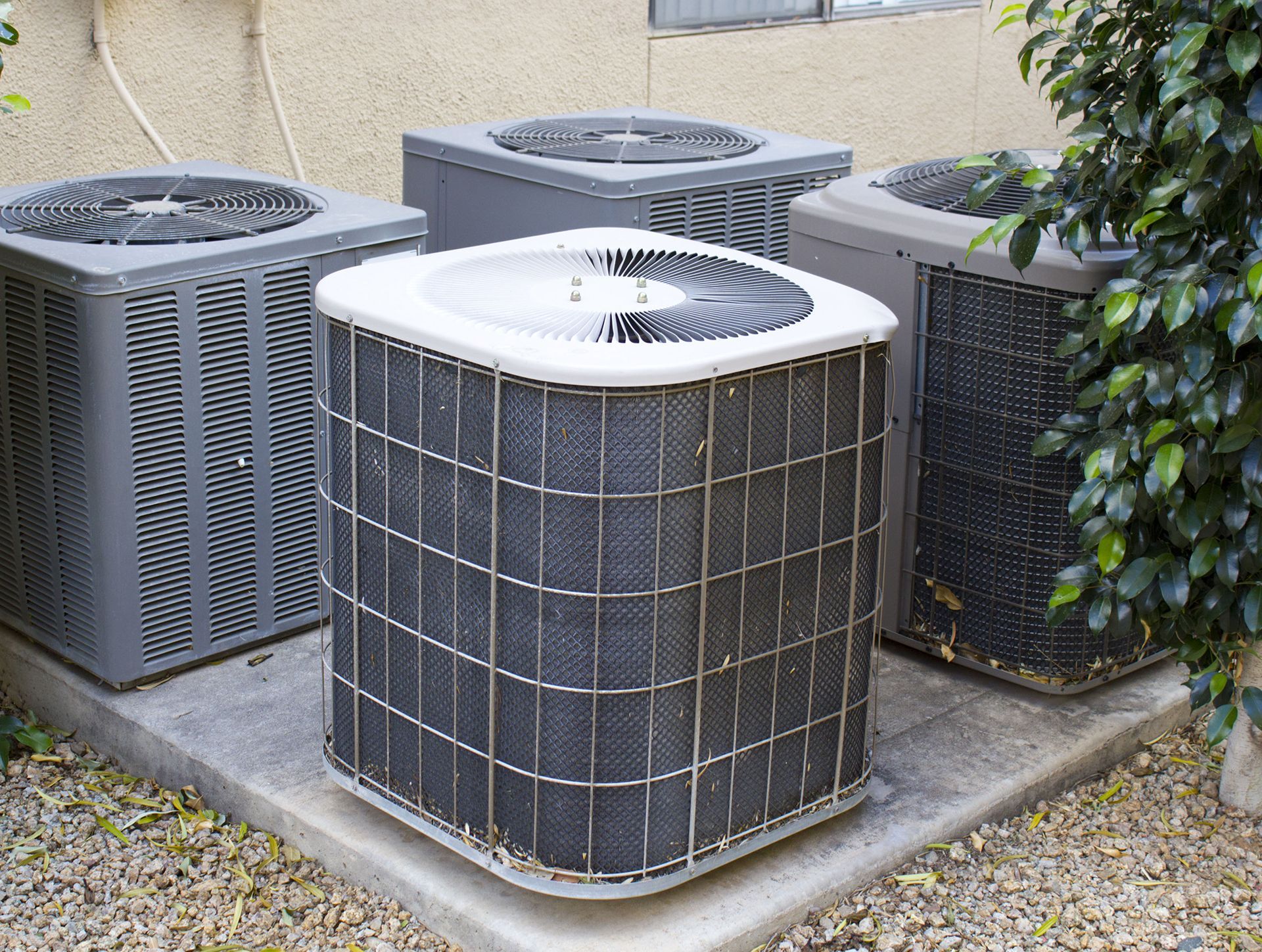 Outdoor HVAC air conditioning units on a concrete pad beside a building.