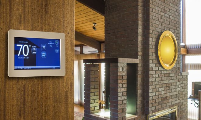 Lobby with a wall-mounted digital display, brick walls, and a round yellow wall mirror.
