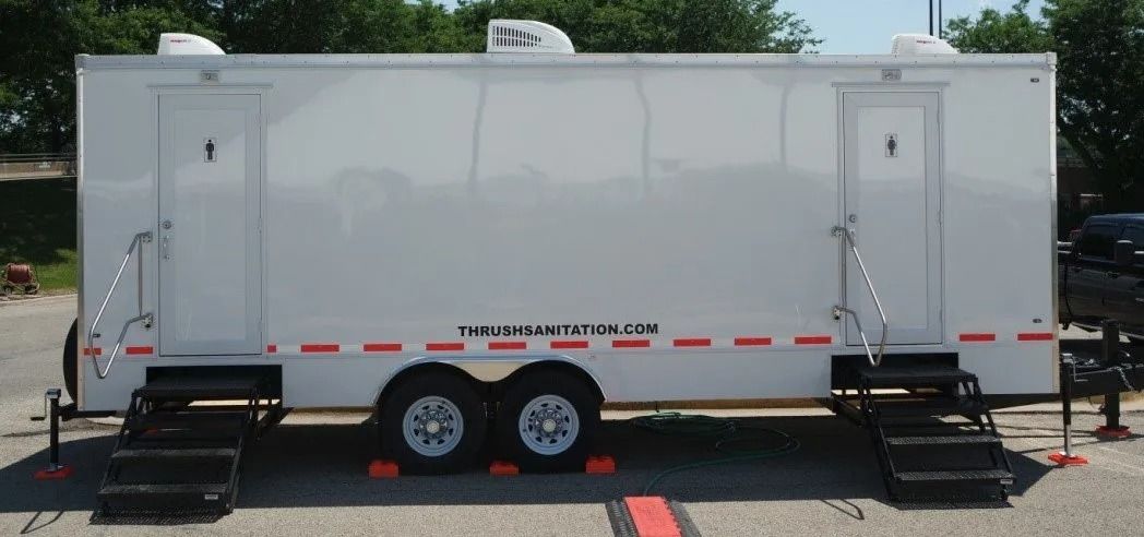 White utility trailer with two side doors and stairs on a paved lot