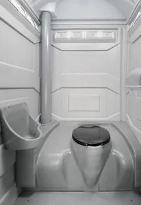 Portable toilet interior with white walls, silver sink, and closed black toilet seat