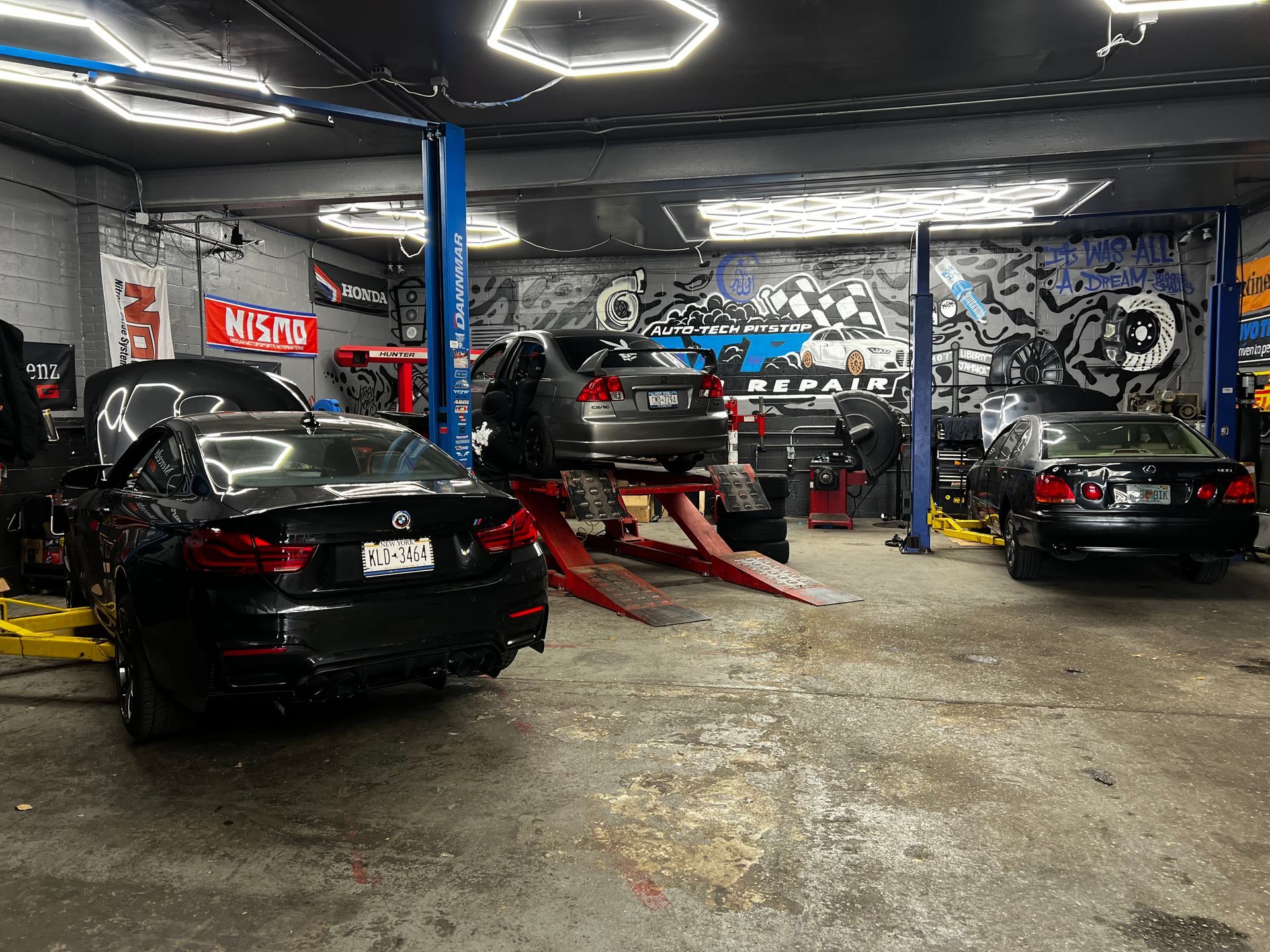 A row of cars are parked in a garage.