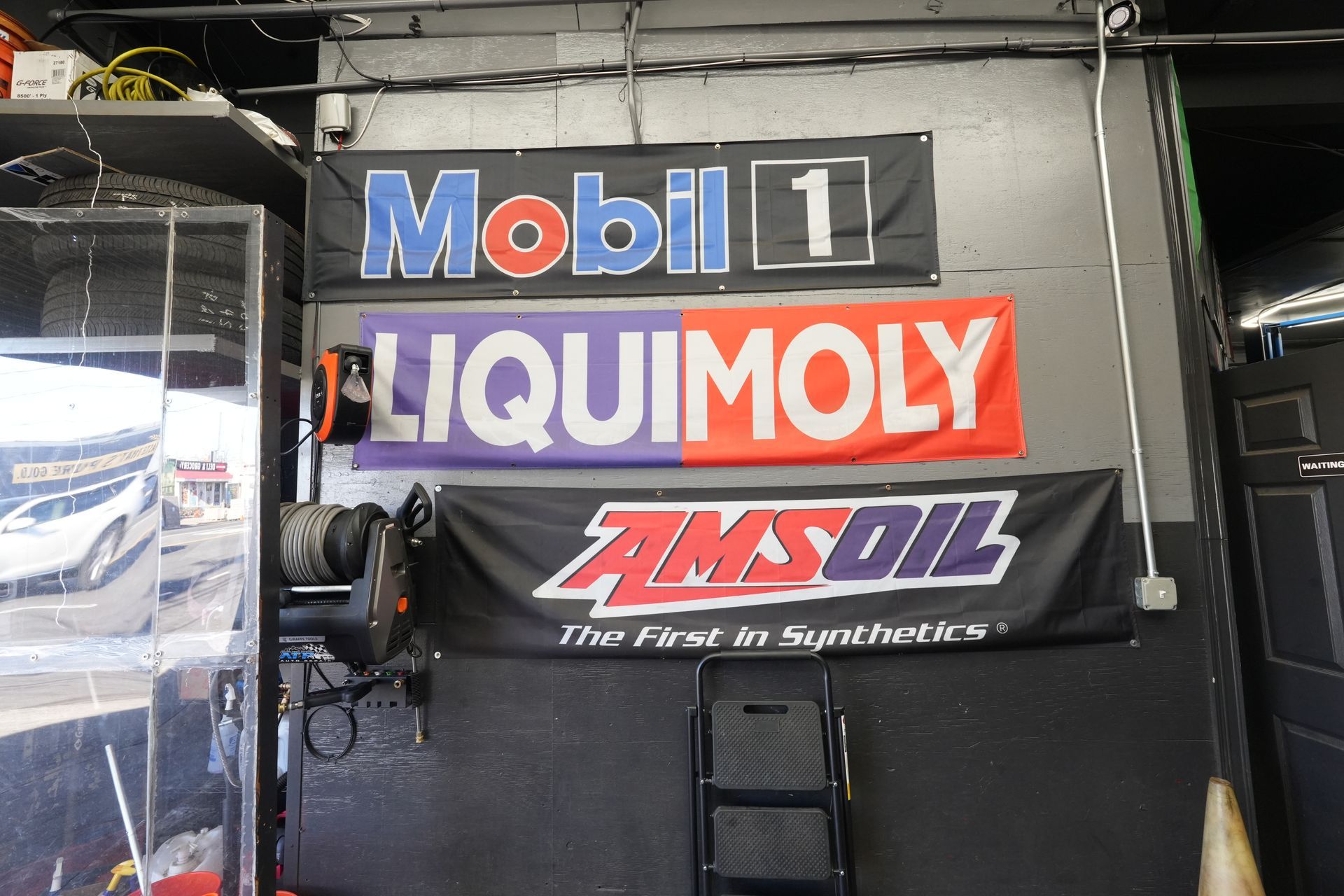 A sign for mobil 1 liquimoly and amsoil hangs on a wall