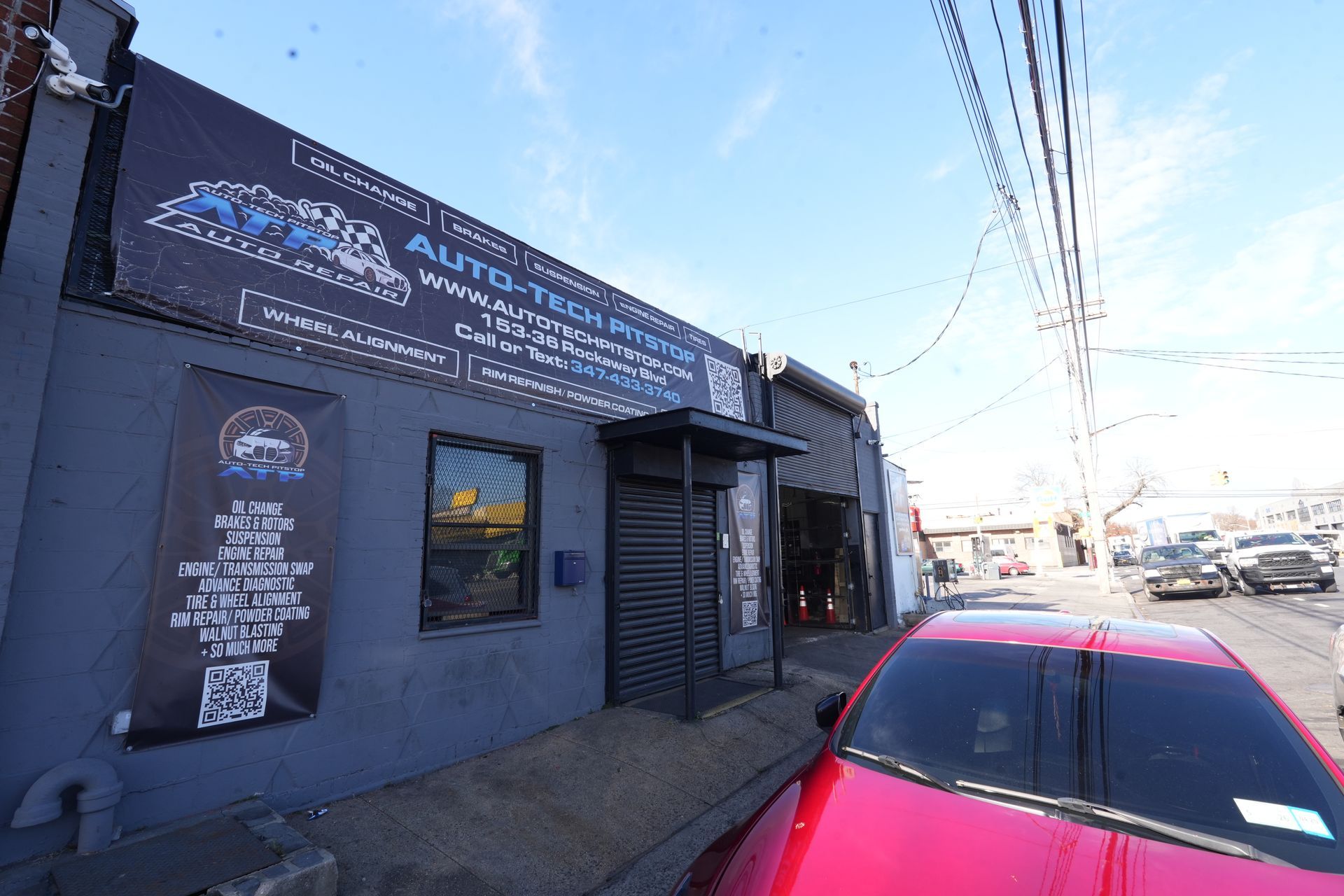 A red car is parked in front of a building.