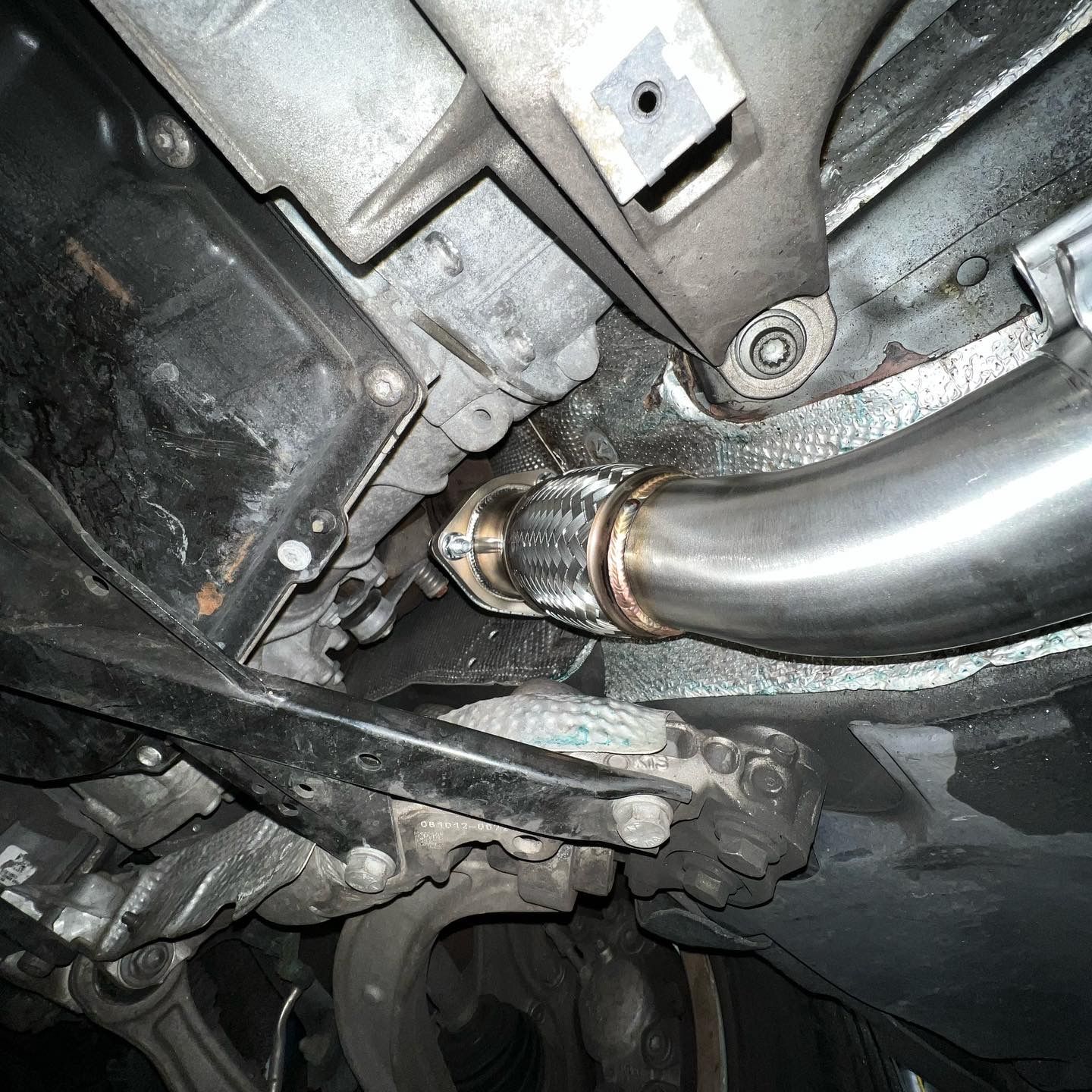 A close up of a exhaust pipe on the underside of a car