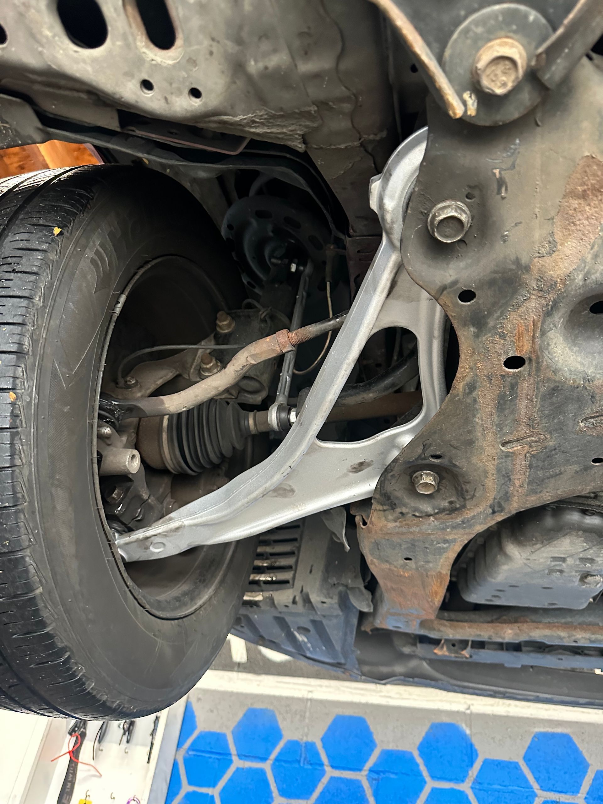 A close up of the underside of a car with a tire.