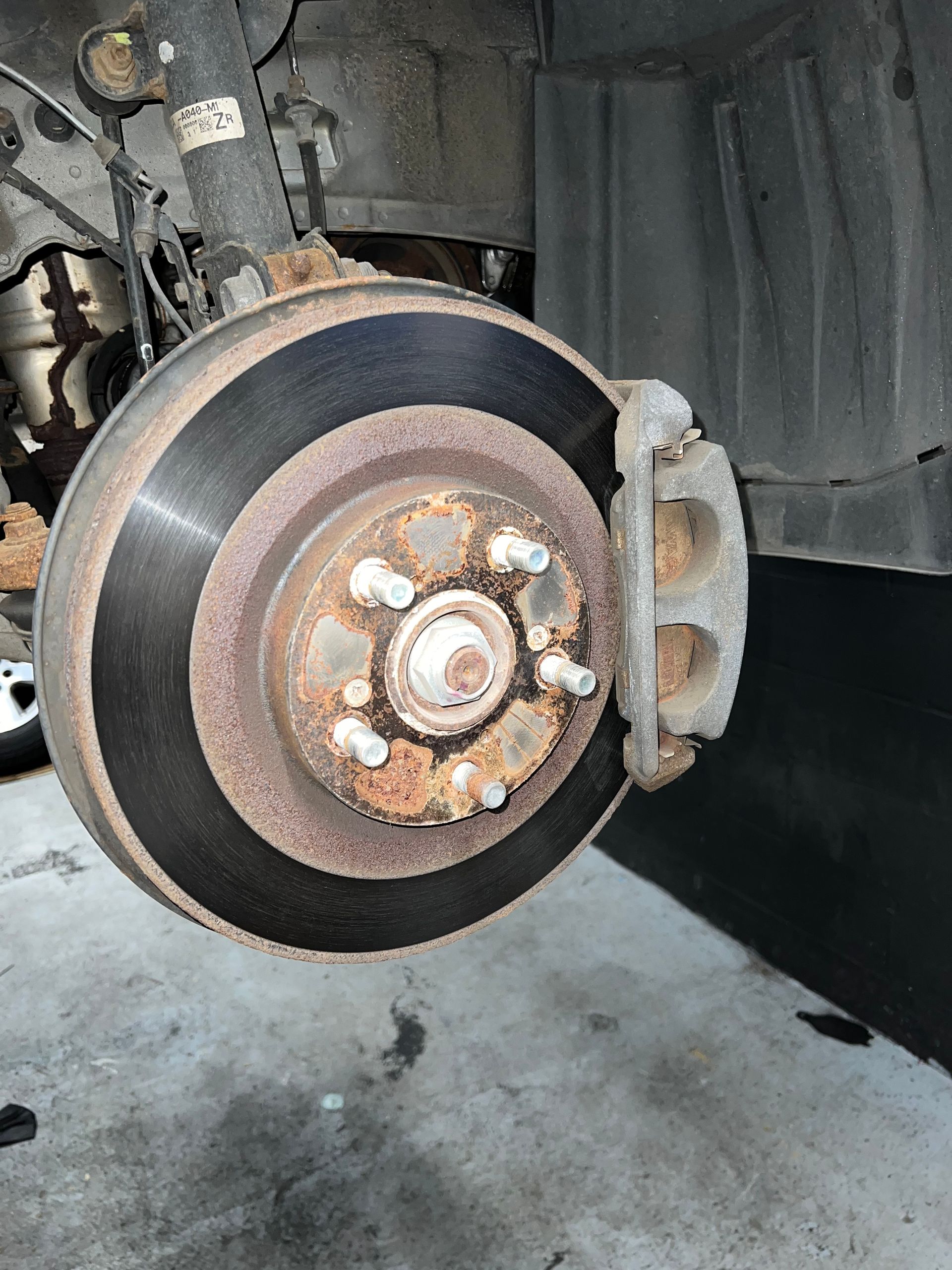 A close up of a rusty brake disc on a car.