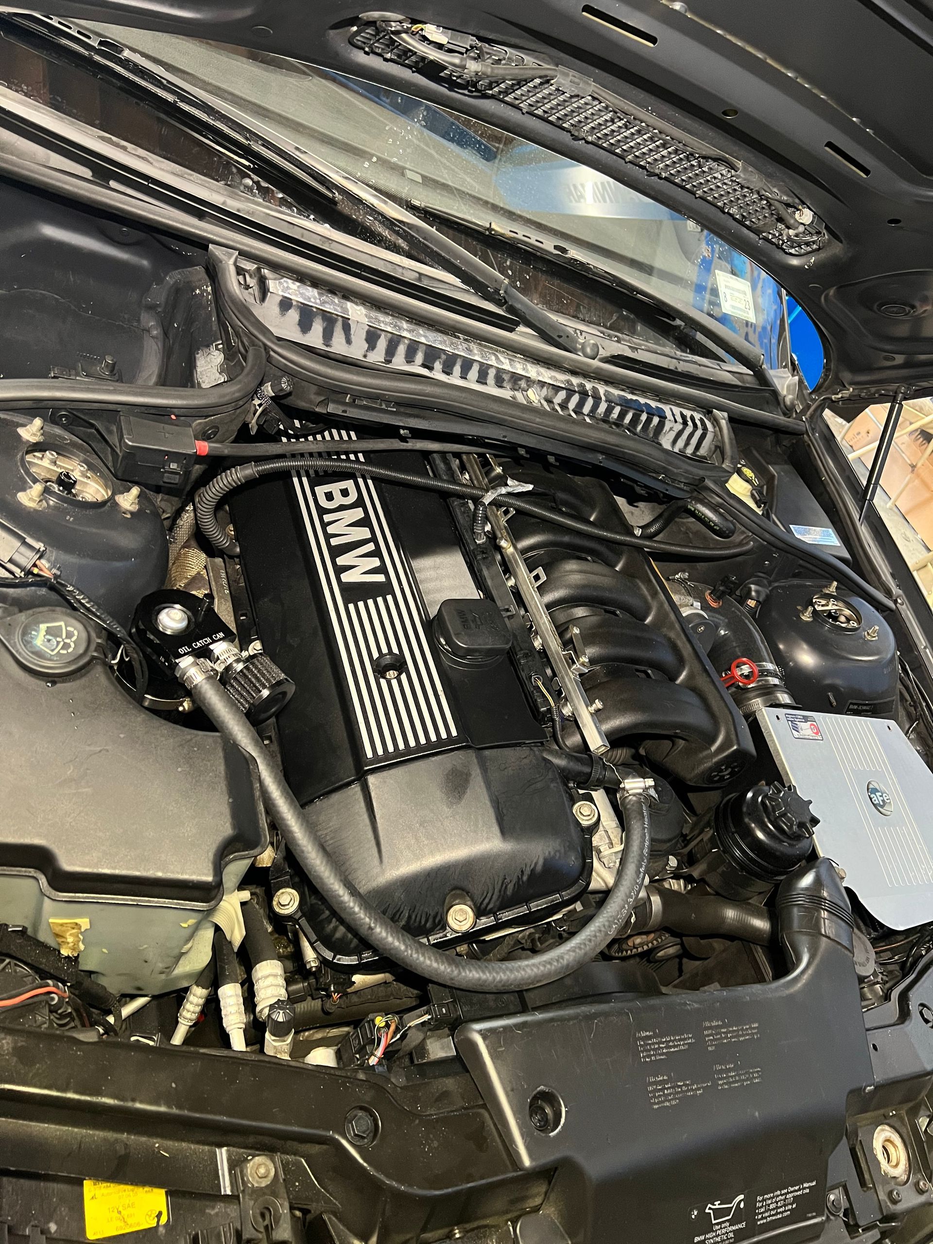 The engine of a bmw is shown with the hood open.