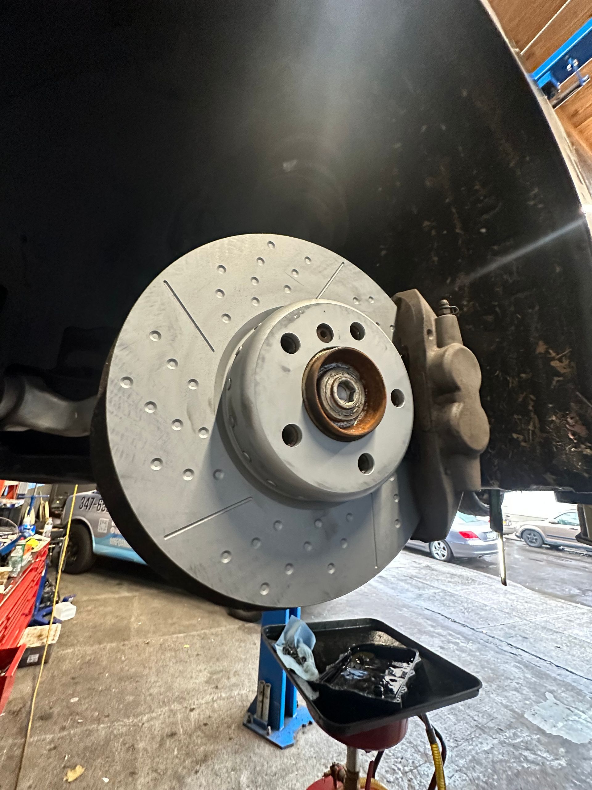 A close up of a brake disc on a car in a garage.