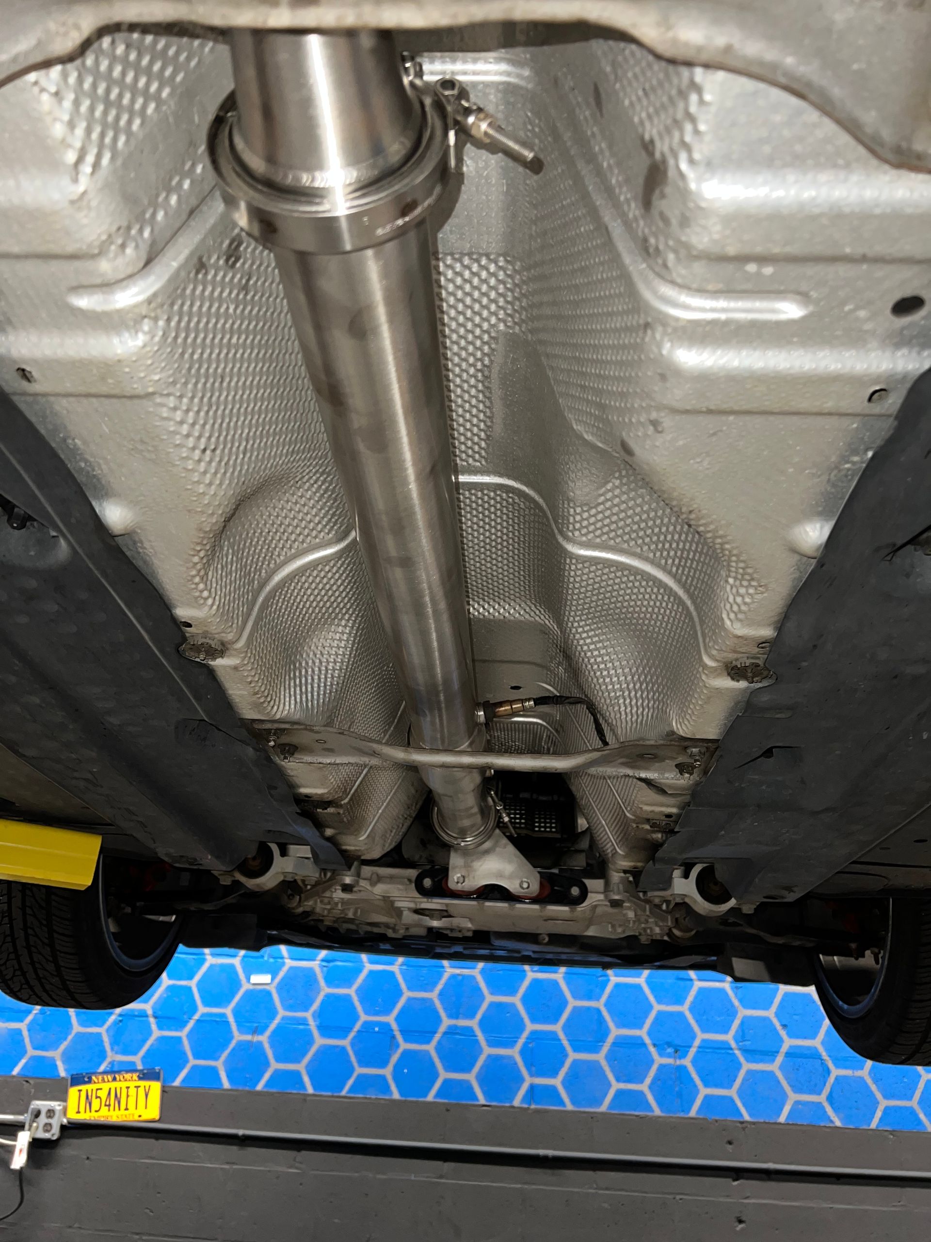 The underside of a car with a exhaust pipe attached to it.