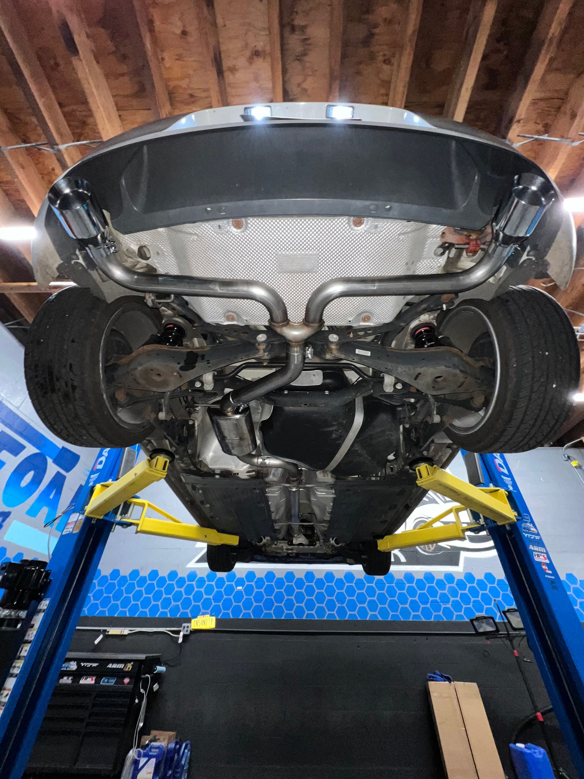 A car is sitting on a lift in a garage.