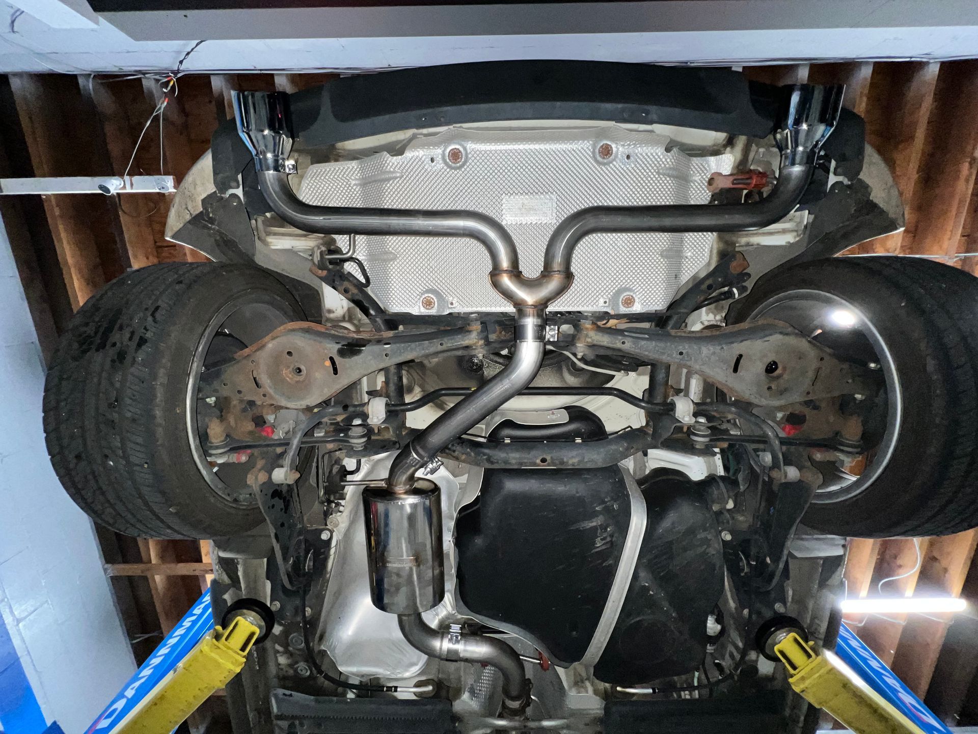 A car is sitting on a lift in a garage.