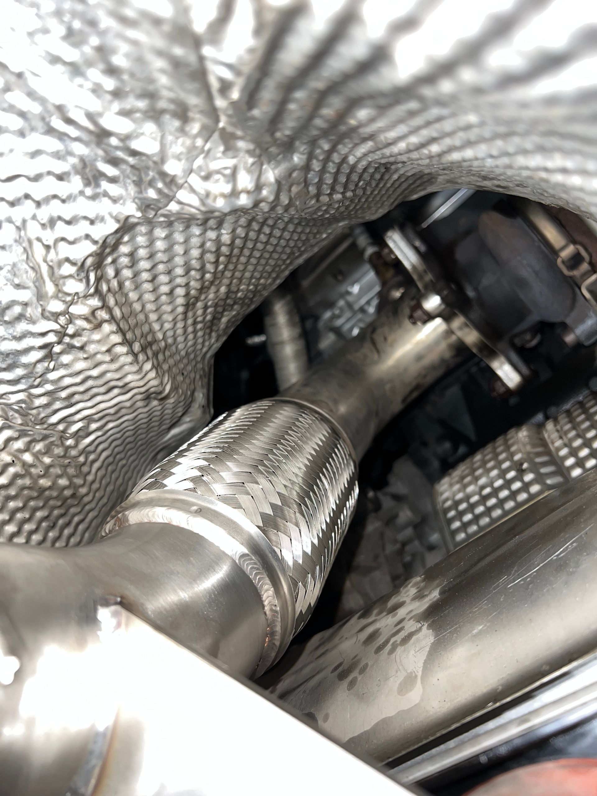 A close up of a stainless steel pipe in a car.
