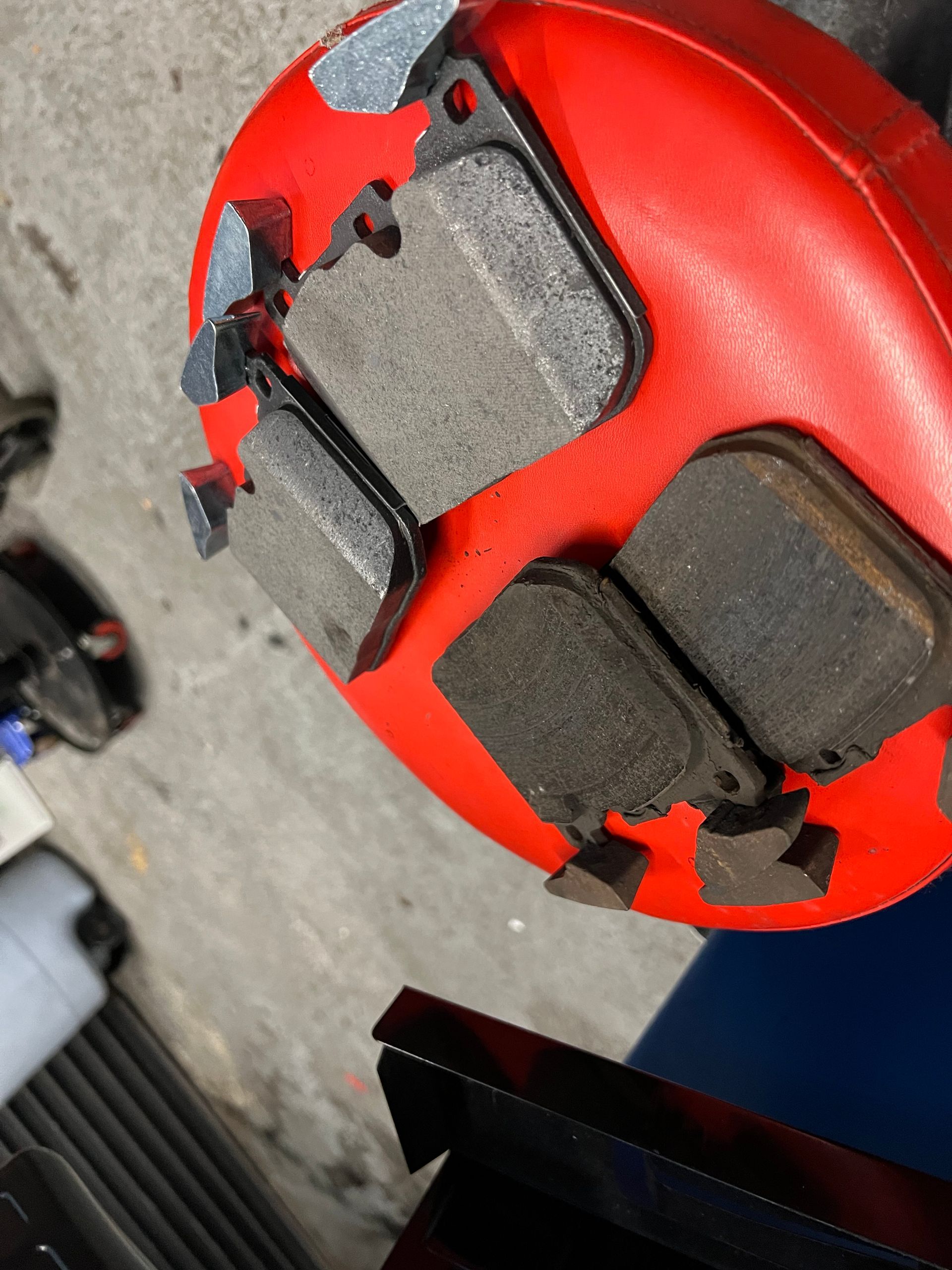 A close up of a red object with brake pads on it