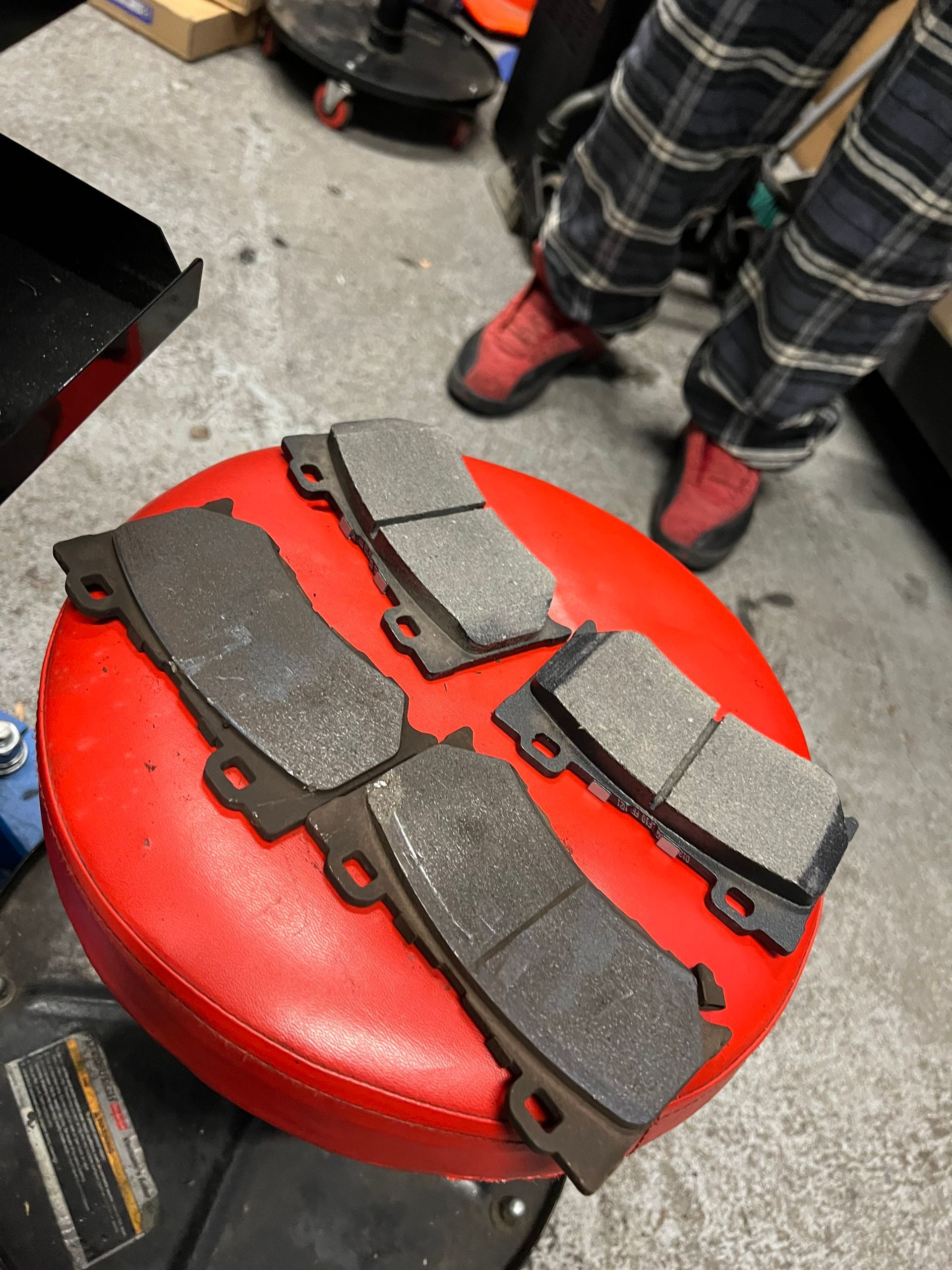 A pair of brake pads are sitting on a red stool