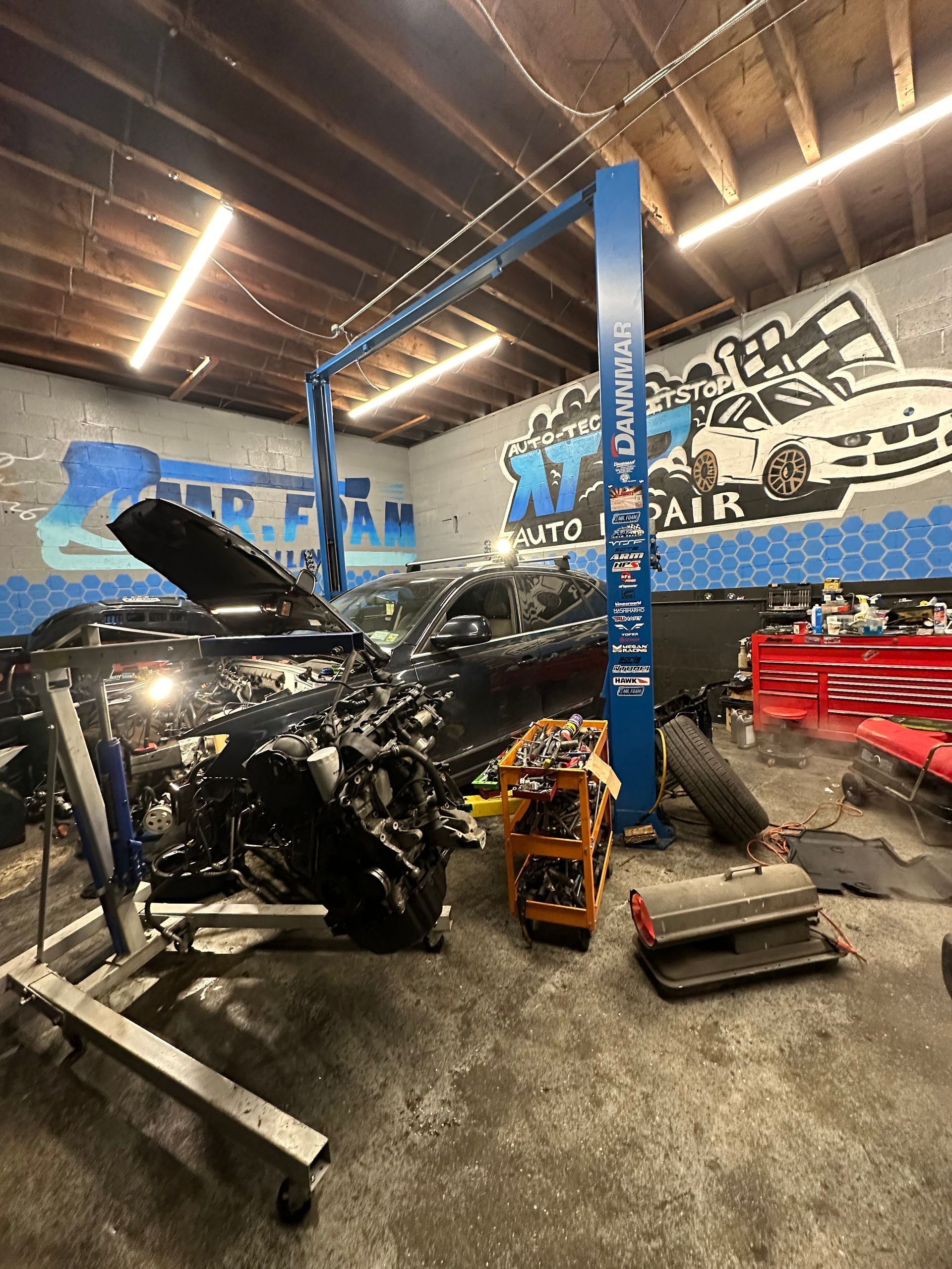 A car is sitting on a lift in a garage.