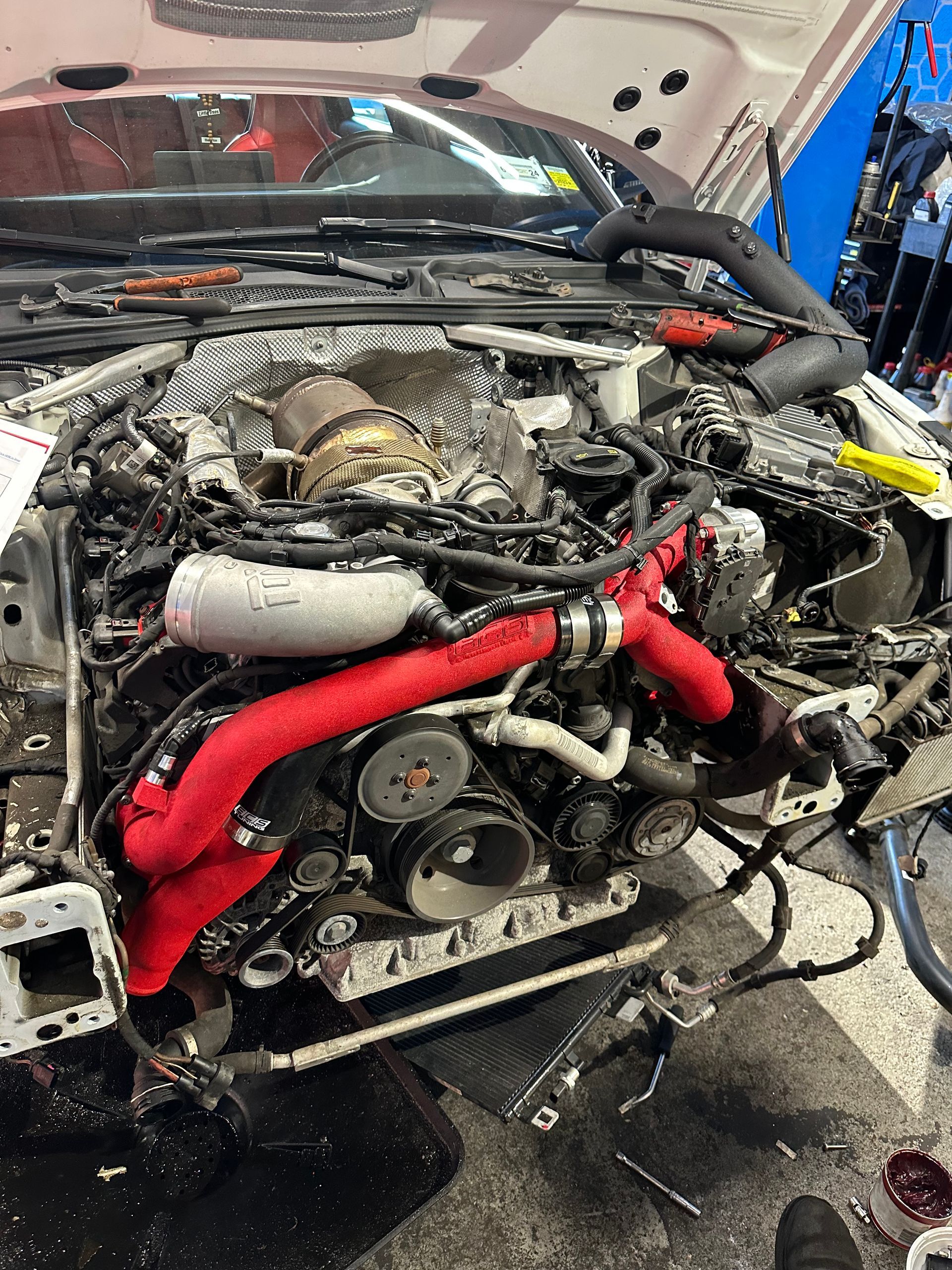 The engine of a car is being worked on in a garage.