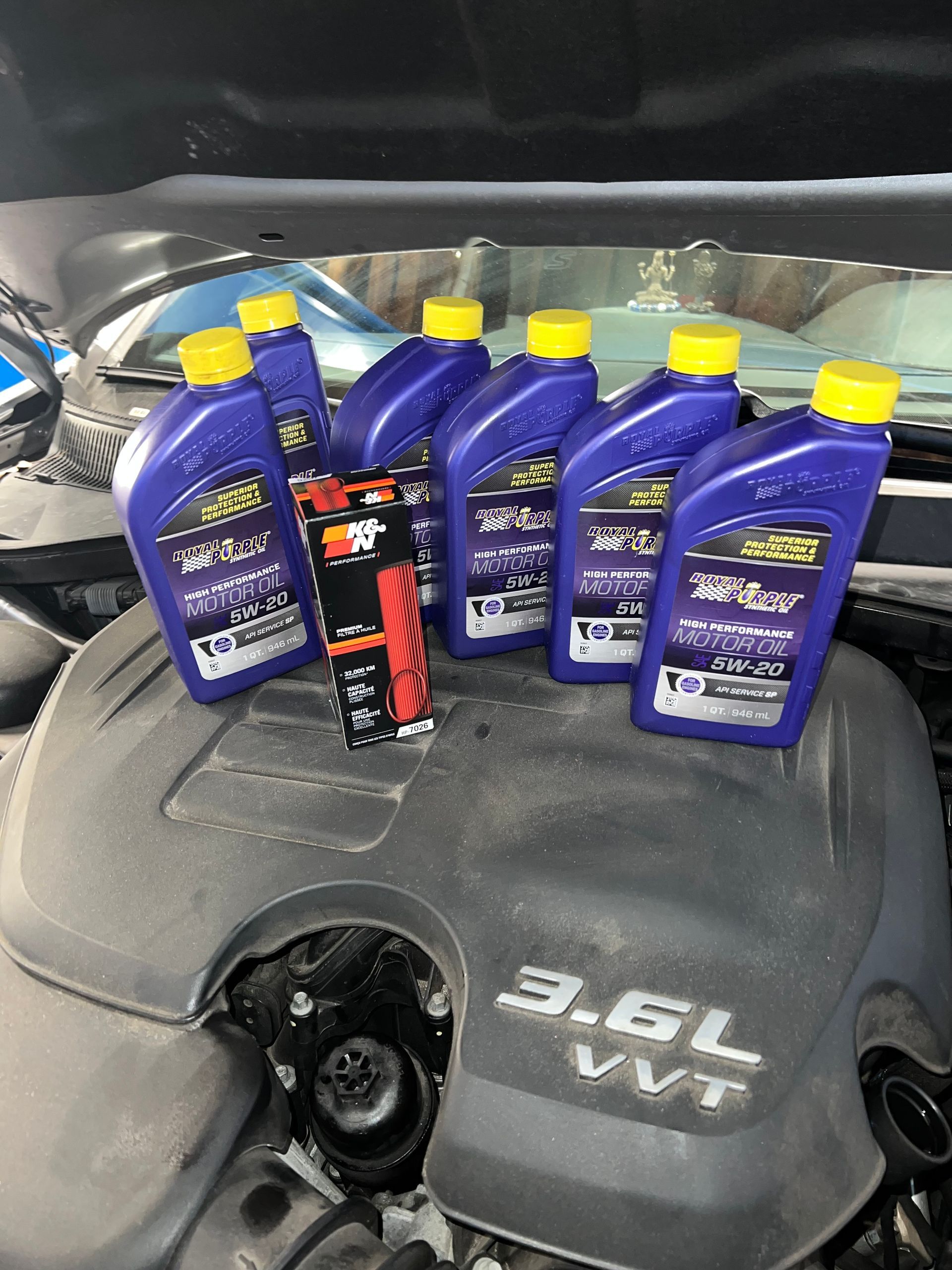Several bottles of oil are sitting on top of a car engine