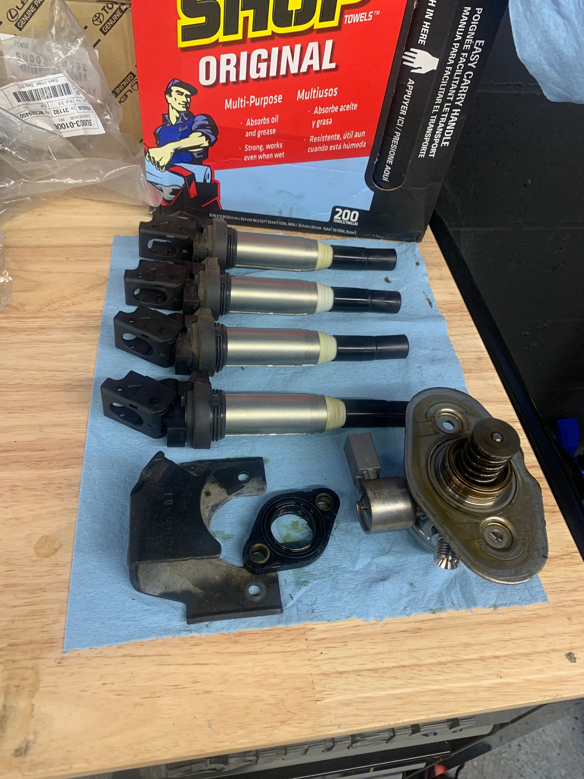 A bunch of spark plugs are sitting on a wooden table.