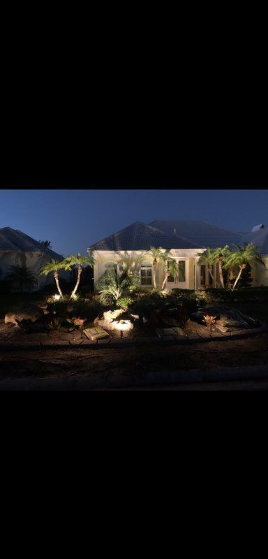 A house is lit up at night with mountains in the background.