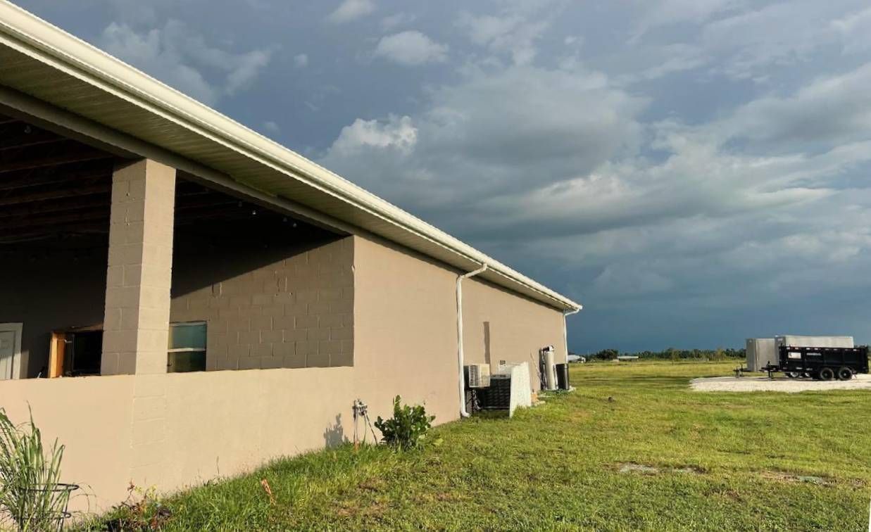 A large building is sitting in the middle of a grassy field.