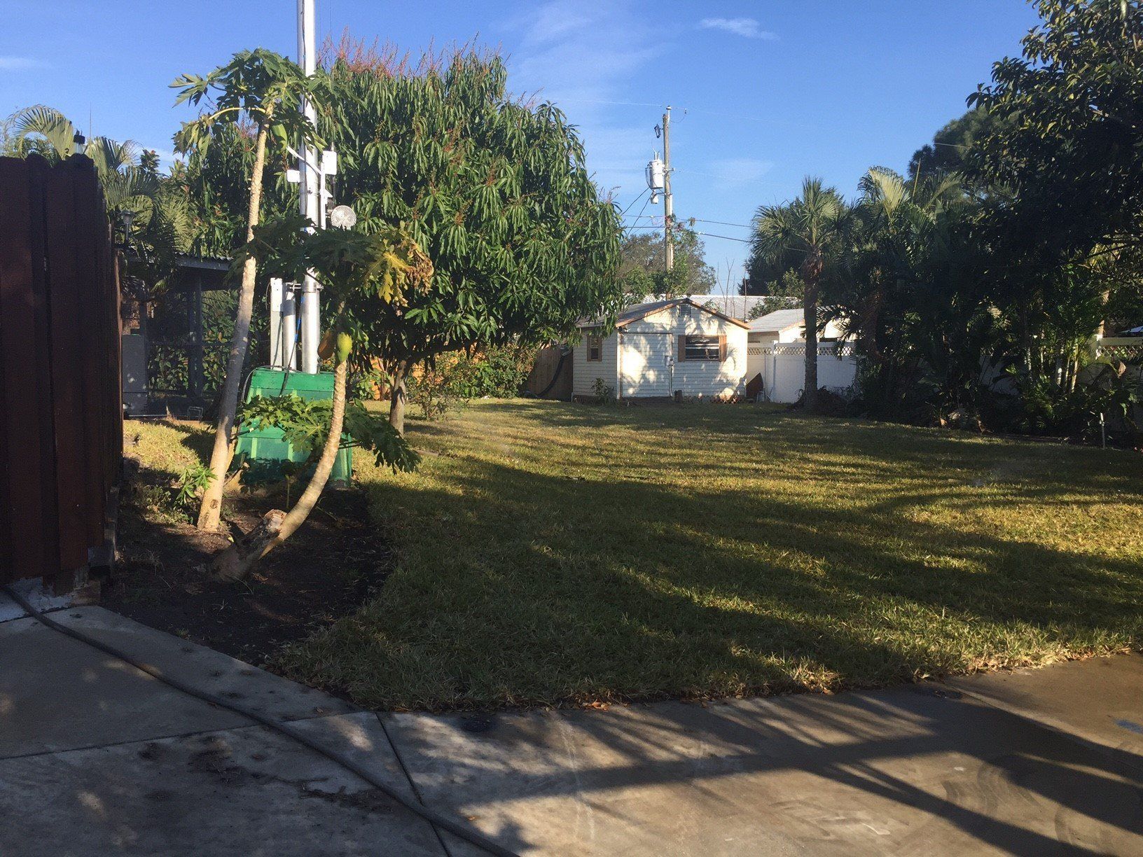 A yard with a fence and a house in the background