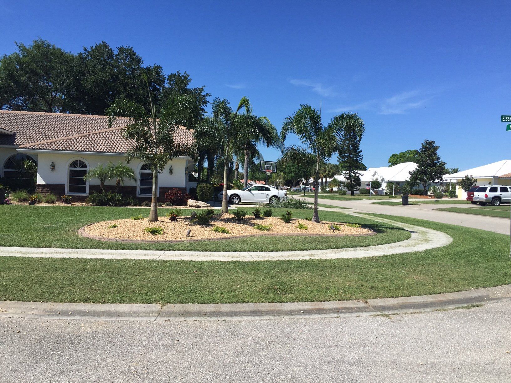 A white truck is parked in front of a house in a residential area.