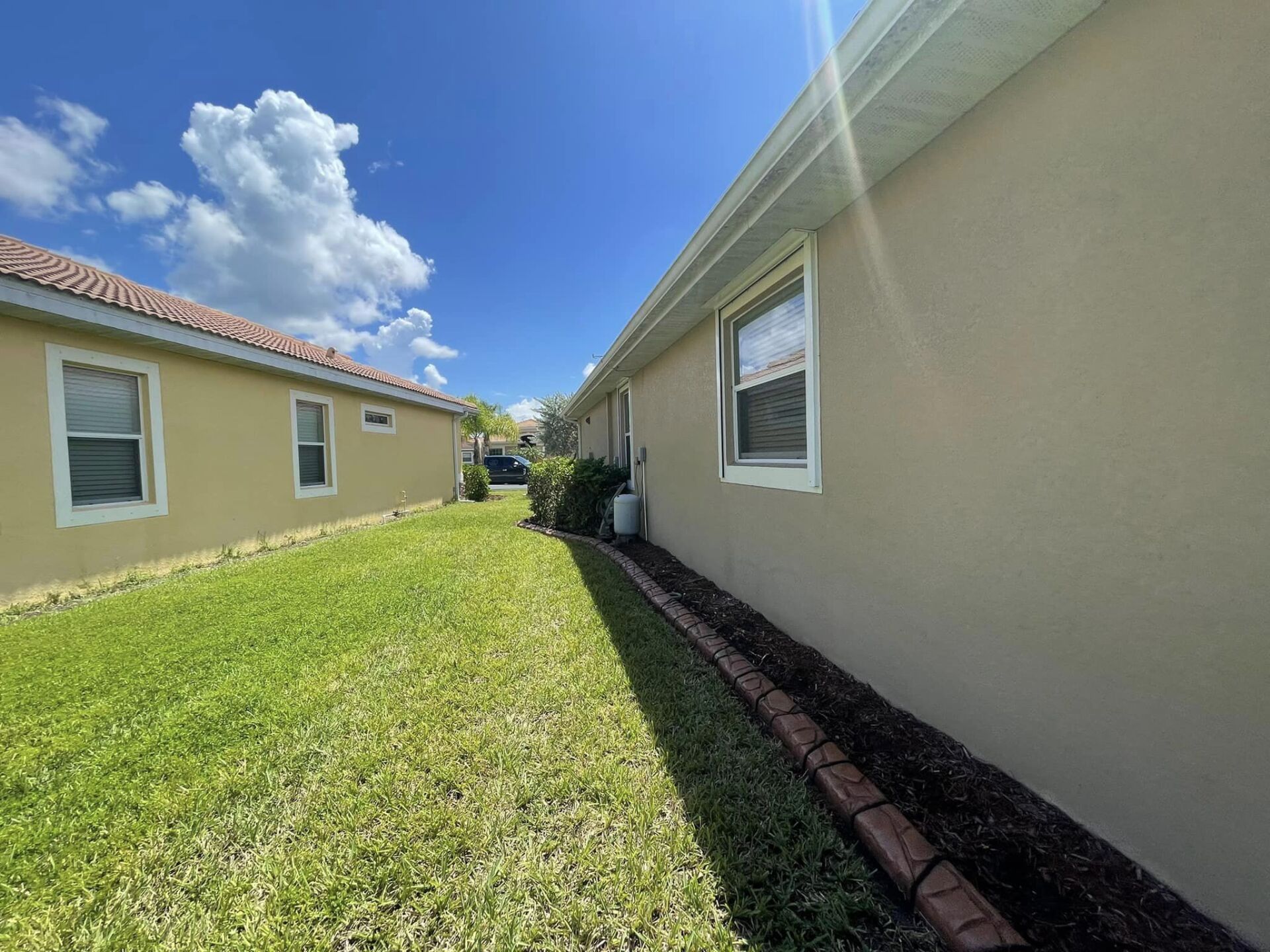 A house with a lot of windows and a lawn in front of it.