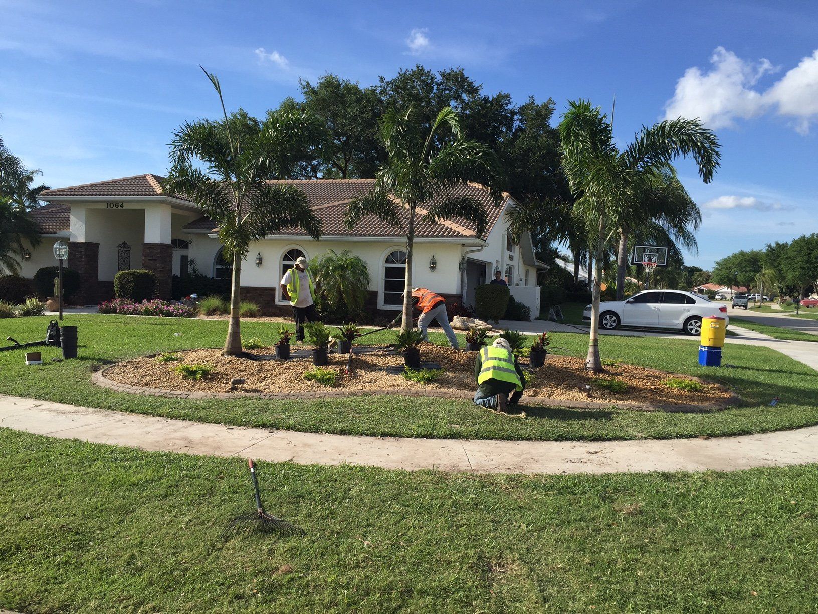 A group of people are working on a lawn in front of a house.