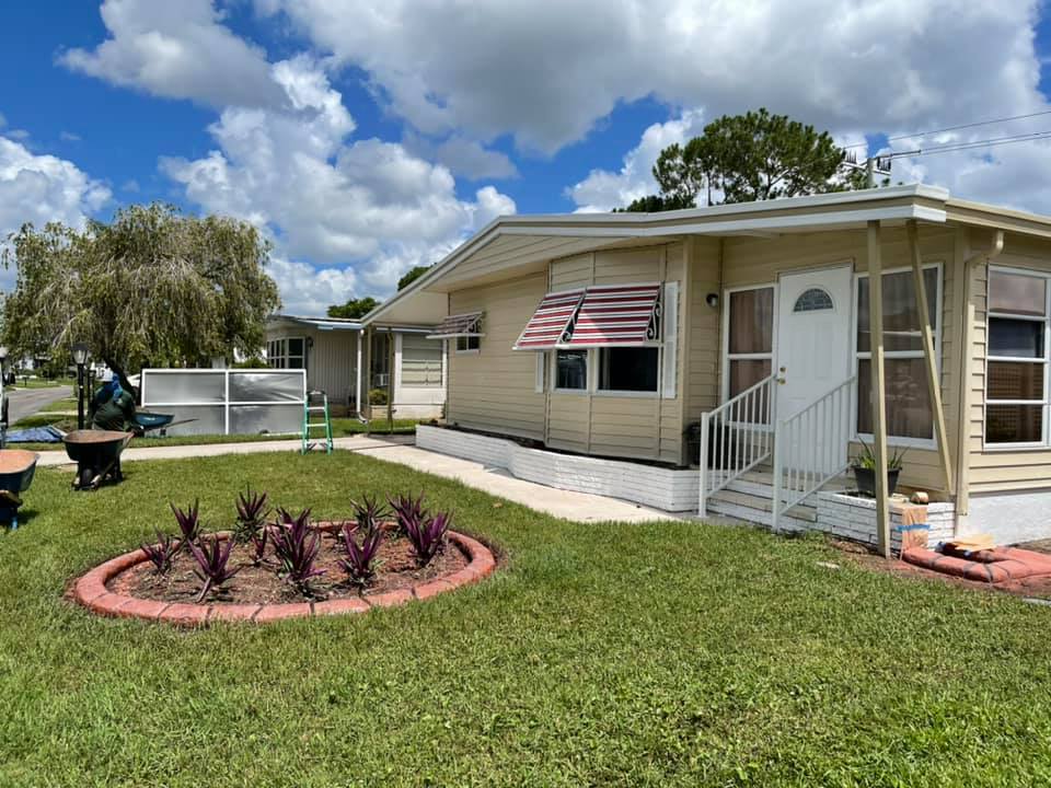 A mobile home with an american flag awning on the front of it.