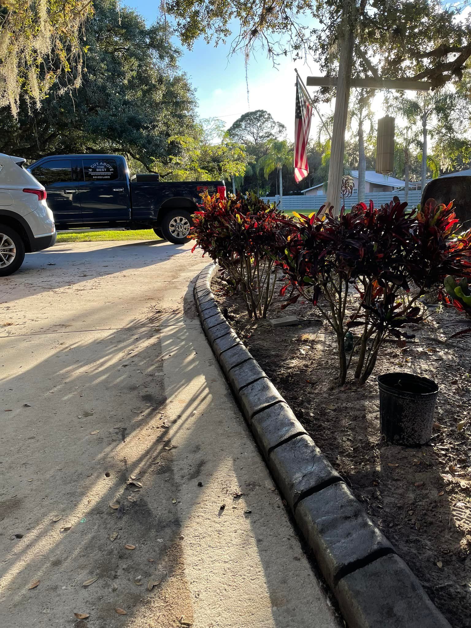 A car is parked on the side of the road next to a bush.