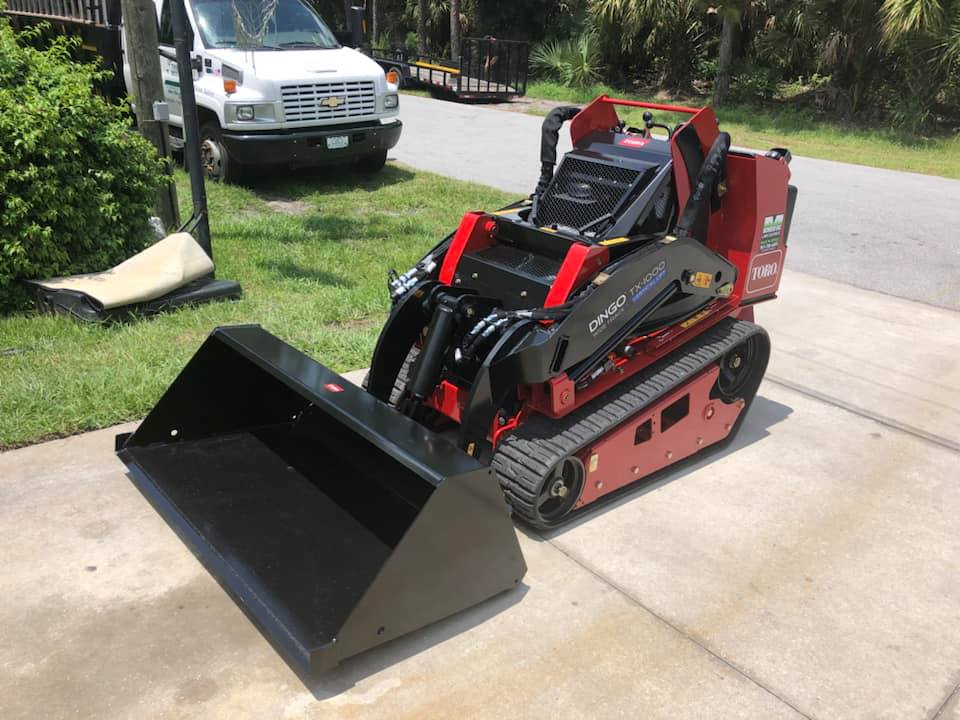 A small tractor with a bucket attached to it