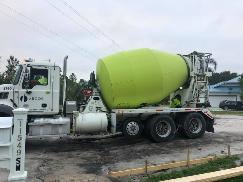 A concrete mixer truck is parked on the side of the road