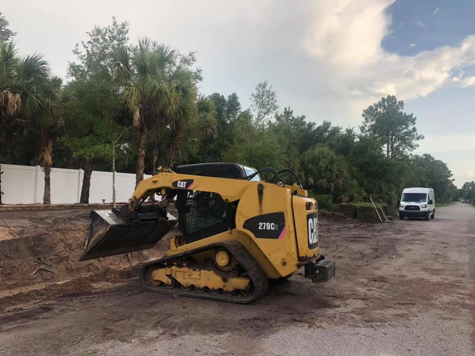 A yellow cat bulldozer is parked on the side of the road.