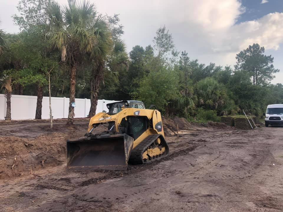 A bulldozer is sitting in the middle of a dirt field.