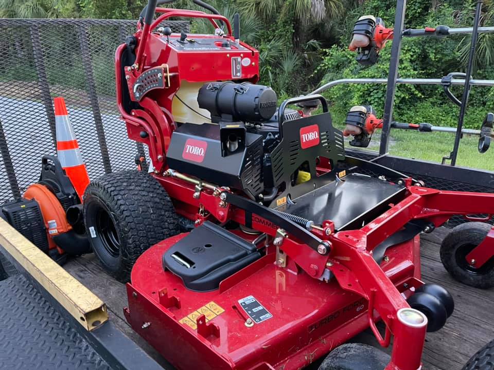 A red lawn mower is sitting on top of a trailer.