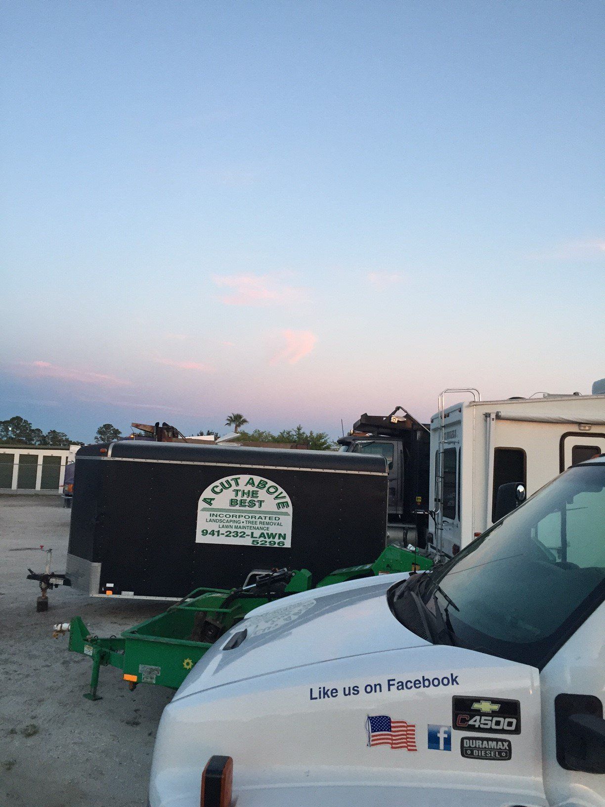 A truck is parked next to a trailer that says like us on facebook