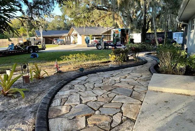 A stone walkway is being built in front of a house.
