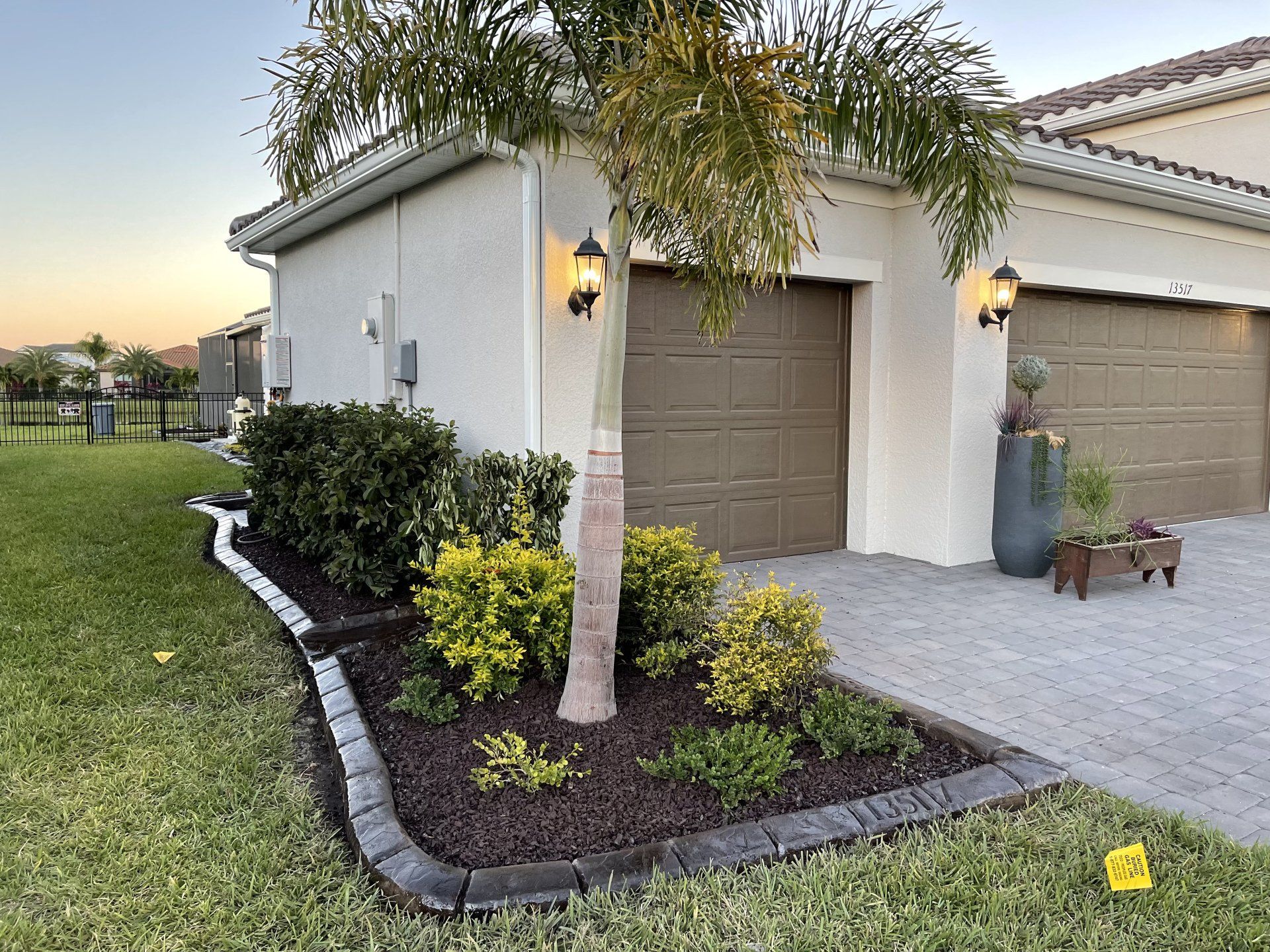 A house with a garage and a tree in front of it