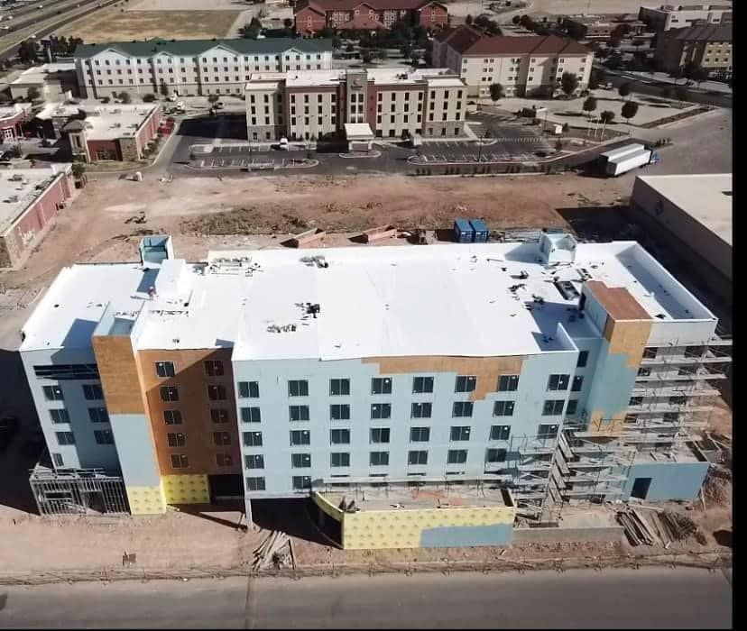 Aerial view of a multi-story hotel under construction with light blue and brown exterior.