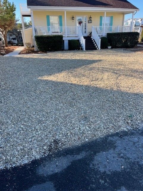 A house with a gravel driveway in front of it