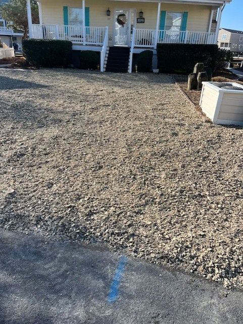 A house with a gravel driveway in front of it.