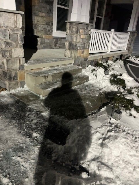 Snow in front of a house at night.