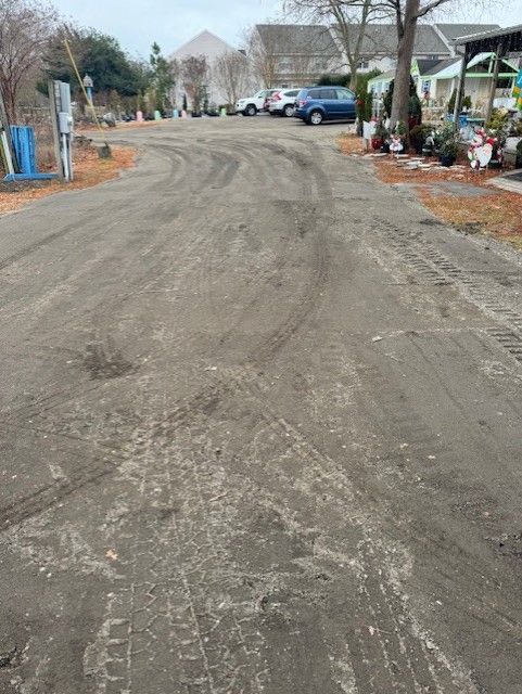 A dirt road with cars parked on the side of it