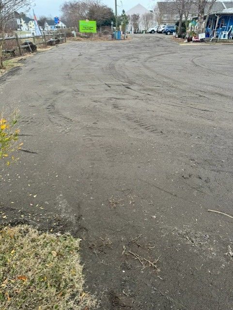 An empty parking lot with a green sign in the background
