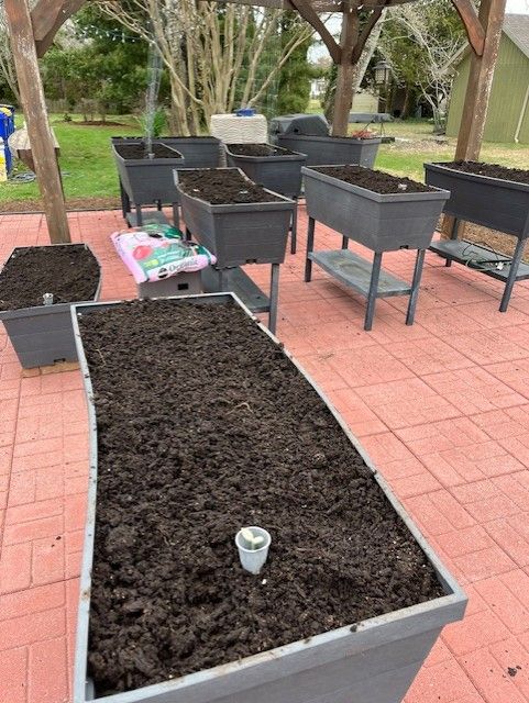 A bunch of planters filled with dirt on a patio.